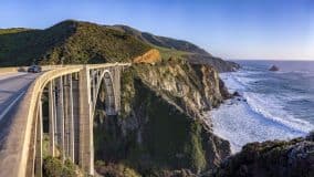 scenic view of california freeway next to the ocean with car