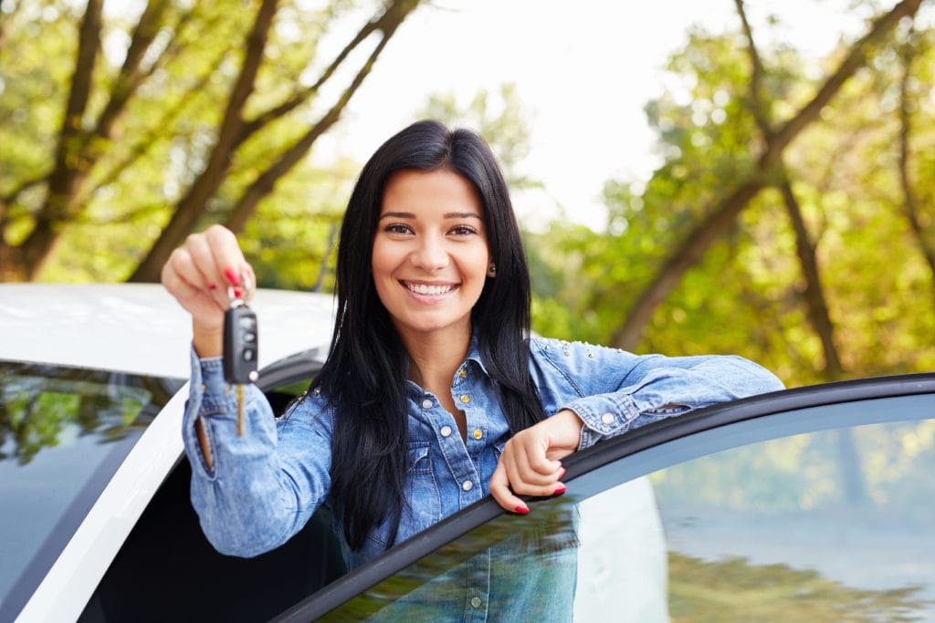 happy girl holding car keys standing with car door non owners insurance