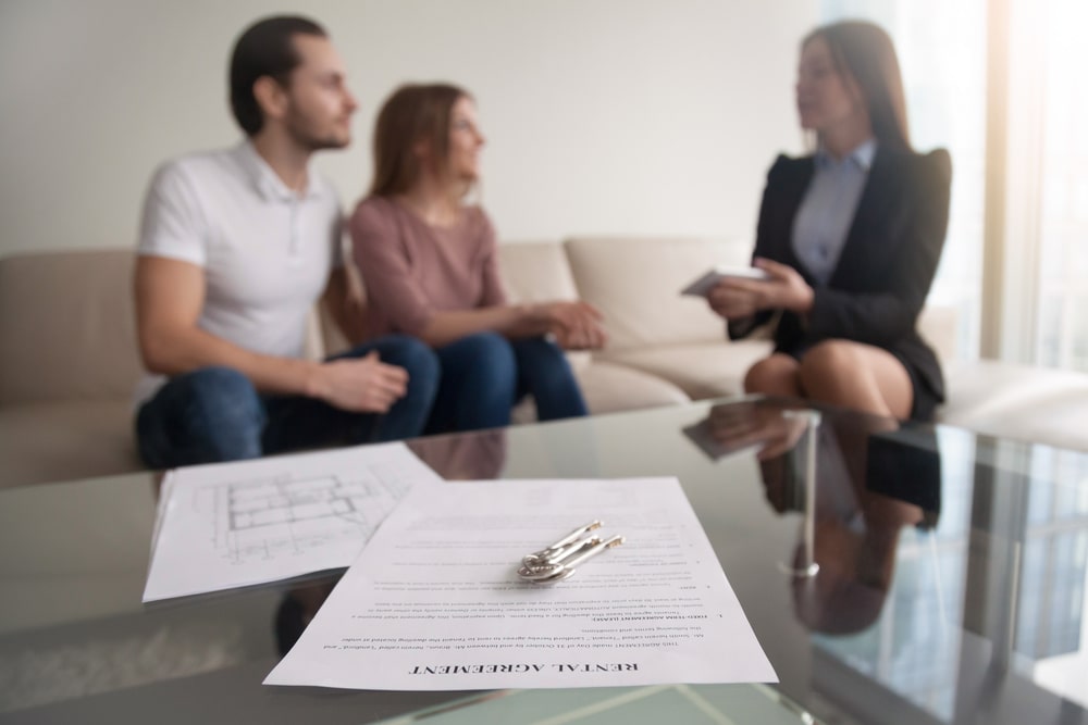 young couple renting for the first time looking over contract with landlord