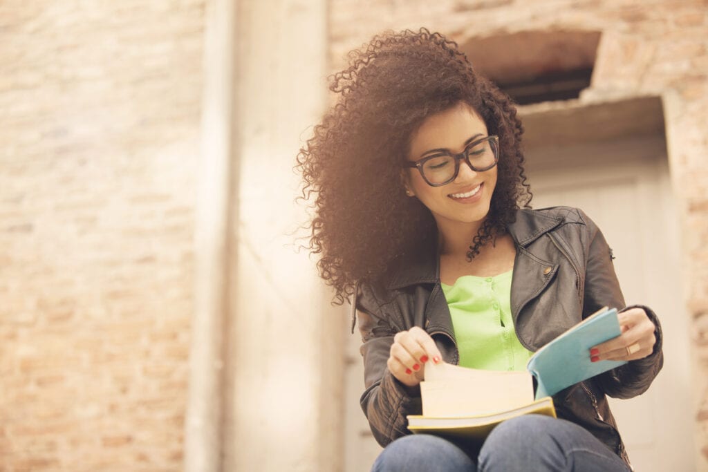 African american young woman smiling with books