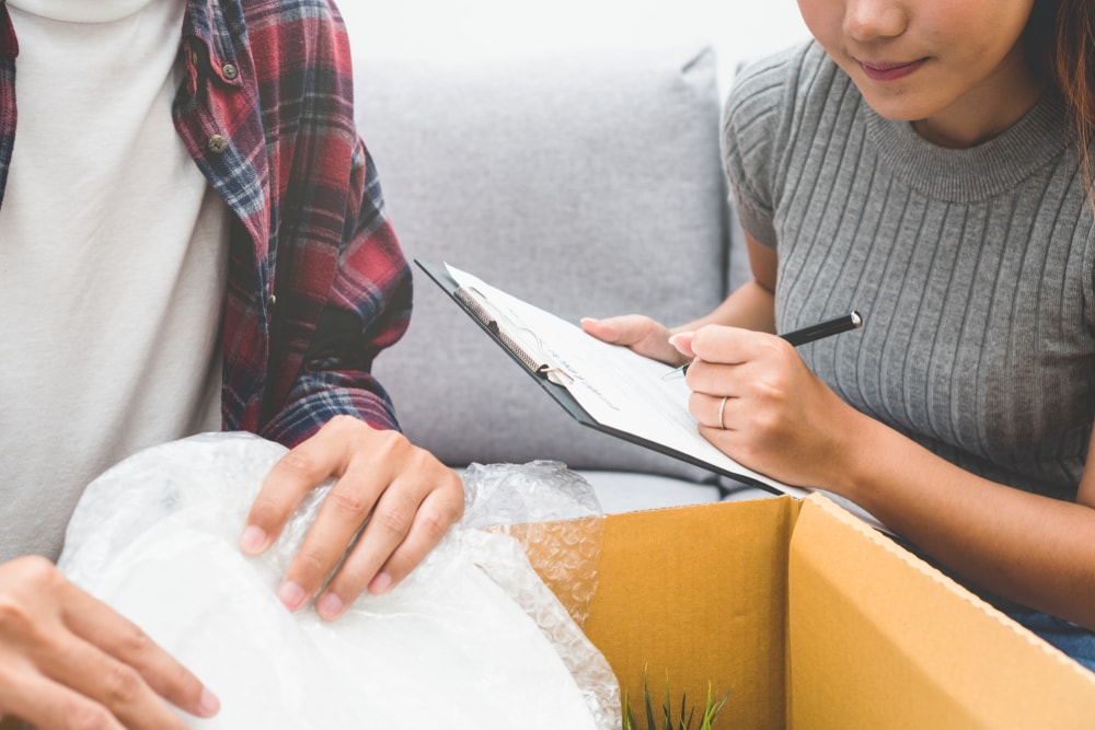 woman making checklist of belongings in new apartment