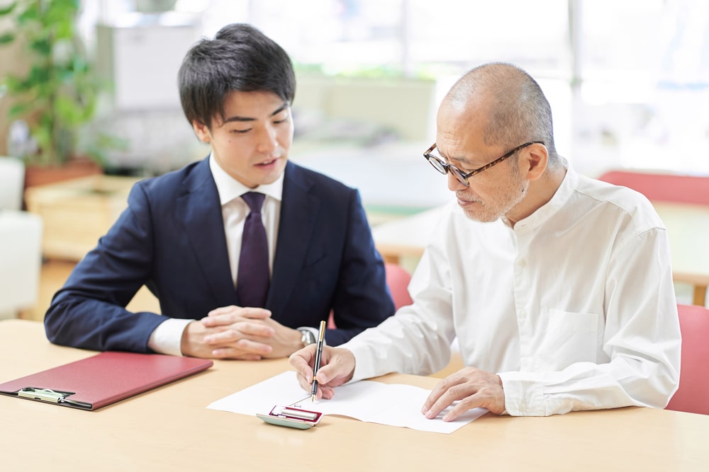 life insurance agent sitting down with elderly client